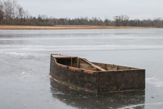 An old wooden boat on the river in the autumn.