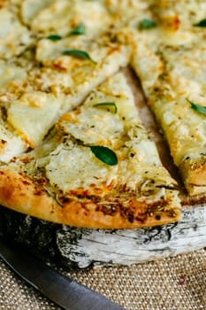 A slice of pizza separated from the main part of the pizza.