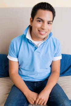 Portrait of a young man sitting on a couch and smiling