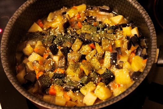 Potatoes with eggplant and carrots, cooked dish on a plate.