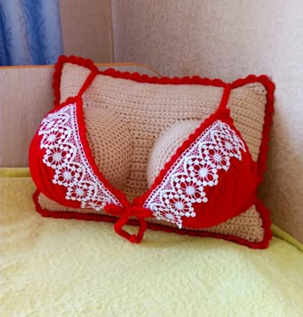 A sofa cushion in the shape of a woman's breast.
