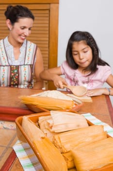 Girl preparing bread with her mother in the kitchen