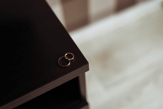 Two wedding rings lie on the edge of the table. Photo rings.