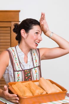 Mid adult woman smiling with a tray of breads in the kitchen