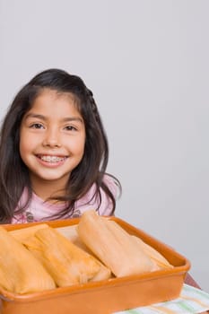 Portrait of a girl smiling with a tray of breads in the kitchen
