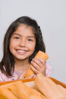 Portrait of a girl holding a bread and smiling in the kitchen