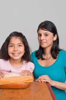 Girl preparing bread with her sister in the kitchen