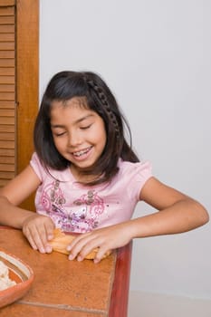 Girl preparing bread in the kitchen and smiling