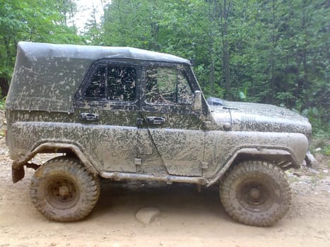 It's a very dirty car. The SUV is driving through the mud.