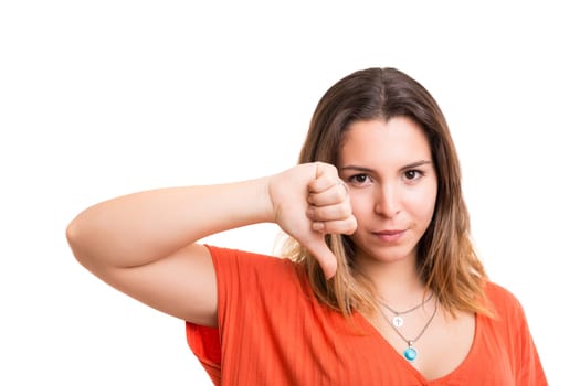 Studio shot of a young woman signaling thumbs down