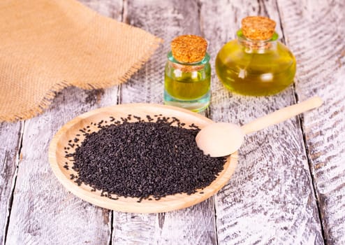 The black sesame and oil on old wooden background
