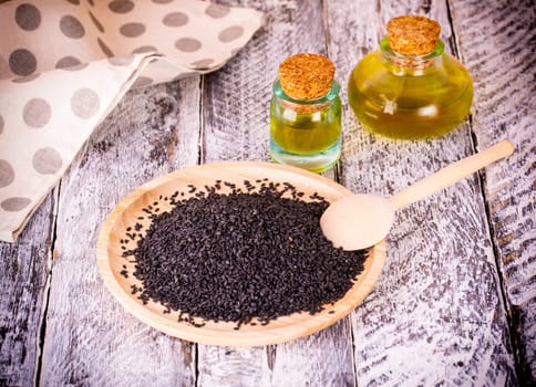The black sesame and oil on old wooden background