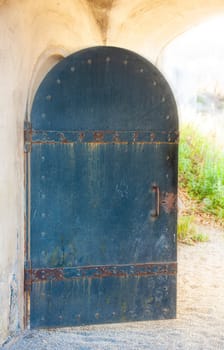 The old opened metal door in a medieval castle close up