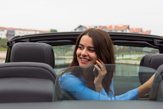 Business woman at the phone while driving