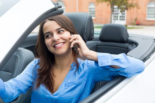 Business woman at the phone while driving