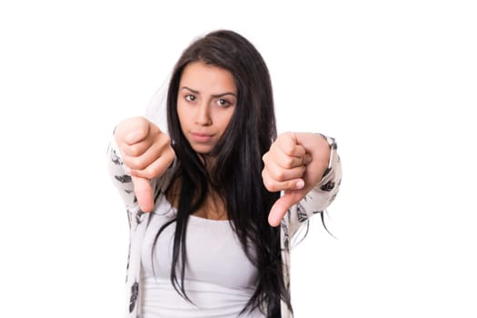 Studio shot of a young woman signaling thumbs down