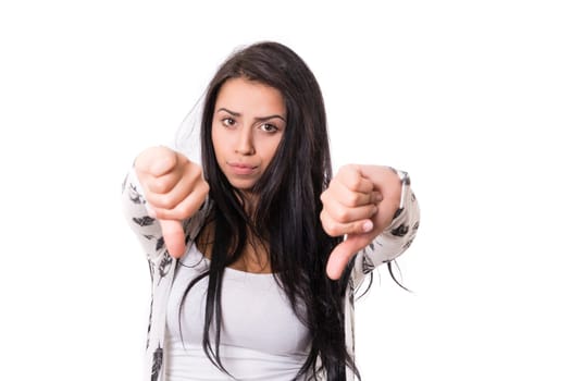 Studio shot of a young woman signaling thumbs down