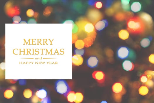 Merry Christmas and Happy New Year greeting card, blurred background of the twinkling lights of the Christmas tree. Greeting card background.