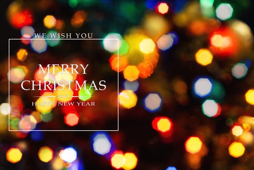 Merry Christmas and Happy New Year greeting card, blurred background of the twinkling lights of the Christmas tree. Greeting card background.
