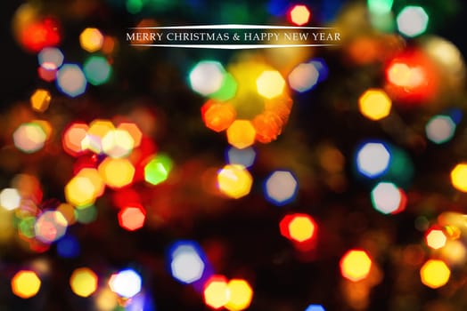 Merry Christmas and Happy New Year greeting card, blurred background of the twinkling lights of the Christmas tree. Greeting card background.