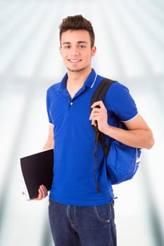 A young and happy student with books and backpack posing