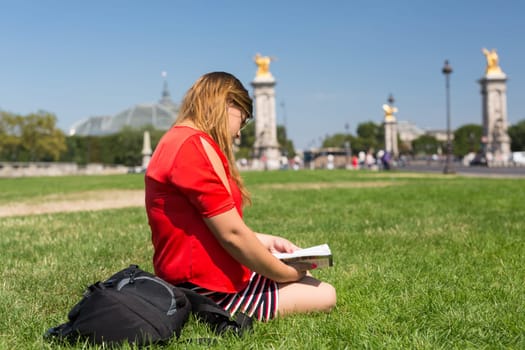 Lucky girl relaxing in the gardens next to the Invalides and the Alexander the 3rd bridge in Paris