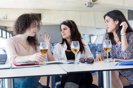 Group of happy students preparing their exams or simply relaxing at a bar