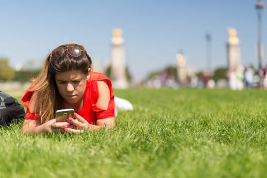Lucky woman in Paris checking her smartphone for news