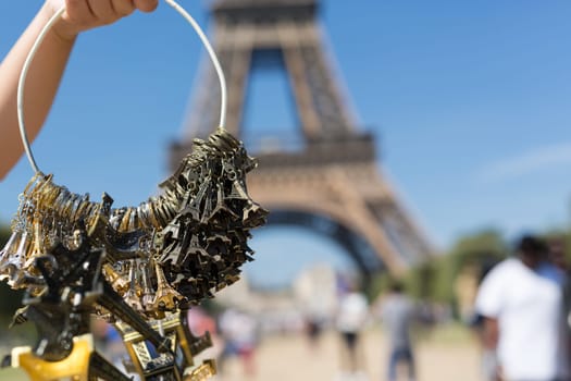 Woman selling small Eiffel Towers in the gardens of the Eiffel Tower, the main attraction in Paris, France