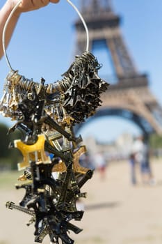 Woman selling small Eiffel Towers in the gardens of the Eiffel Tower, the main attraction in Paris, France