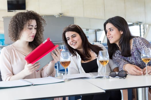 Group of happy students preparing their exams or simply relaxing at a bar