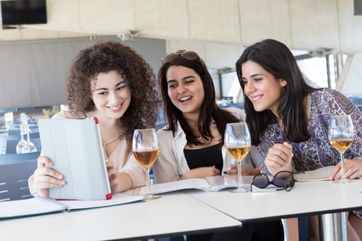 Group of happy students preparing their exams or simply relaxing at a bar