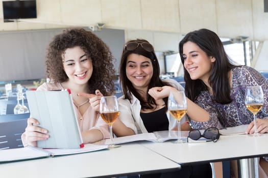Group of happy students preparing their exams or simply relaxing at a bar