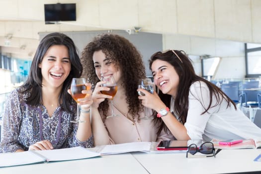 Group of happy students preparing their exams or simply relaxing at a bar