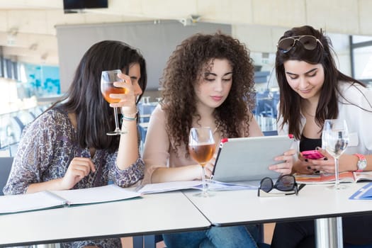 Group of happy students preparing their exams or simply relaxing at a bar