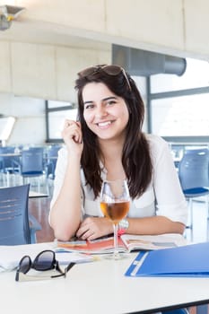Happy student preparing her exams or simply relaxing at a bar