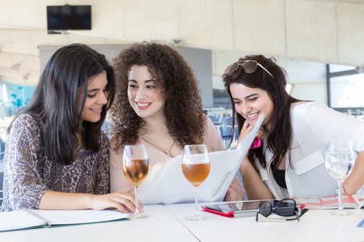 Group of happy students preparing their exams or simply relaxing at a bar