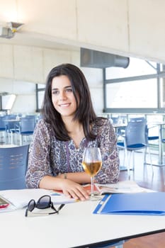 Happy student preparing her exams or simply relaxing at a bar