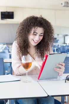 Happy student preparing her exams or simply relaxing at a bar