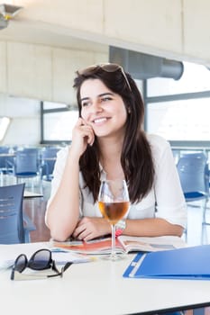Happy student preparing her exams or simply relaxing at a bar