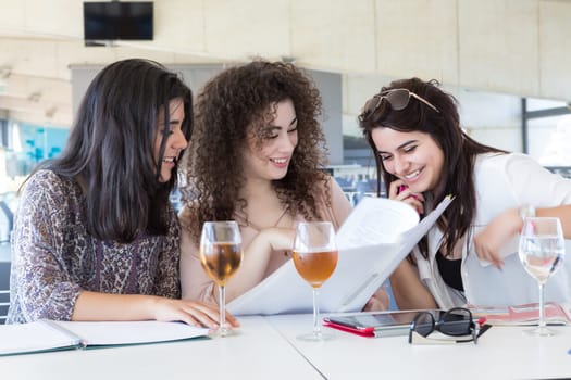 Group of happy students preparing their exams or simply relaxing at a bar