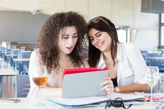 Group of happy students preparing their exams or simply relaxing at a bar