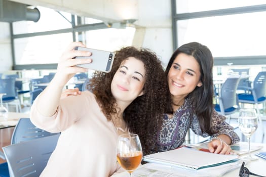 Group of happy students preparing their exams or simply relaxing at a bar