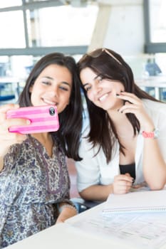 Group of happy students preparing their exams or simply relaxing at a bar