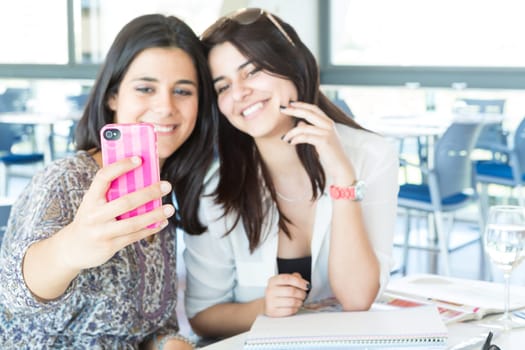 Group of happy students preparing their exams or simply relaxing at a bar
