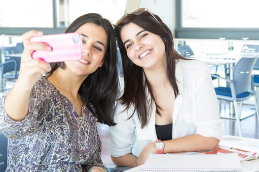 Group of happy students preparing their exams or simply relaxing at a bar