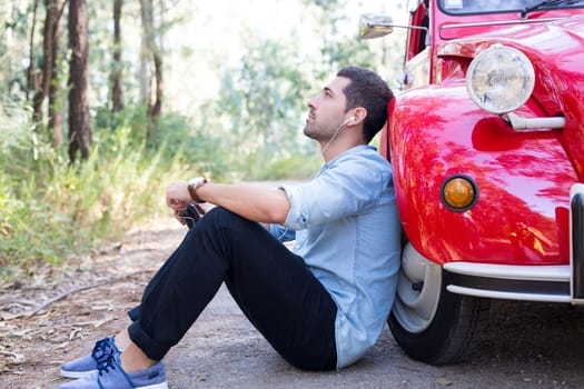 Young man resting at car trip by the countryside