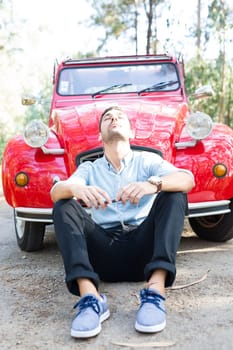 Young man resting at car trip by the countryside