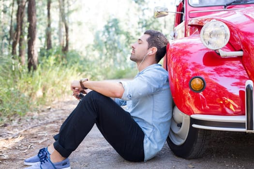 Young man resting at car trip by the countryside