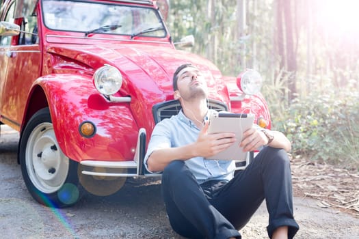 Young man resting at car trip by the countryside